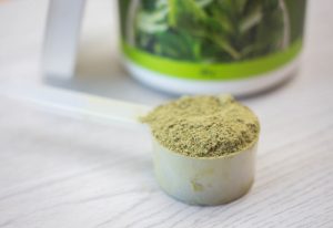 Green Powder Supplement in a Spoon
