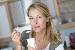 Portrait of middle-aged woman eating yoghurt